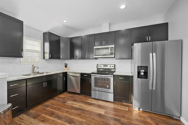 kitchen featuring a sink, dark wood-type flooring, light stone countertops, and stainless steel appliances