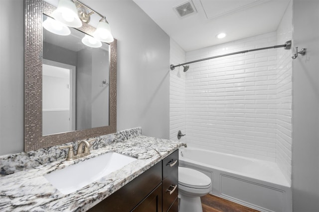 bathroom with visible vents, toilet, wood finished floors, shower / bathing tub combination, and vanity