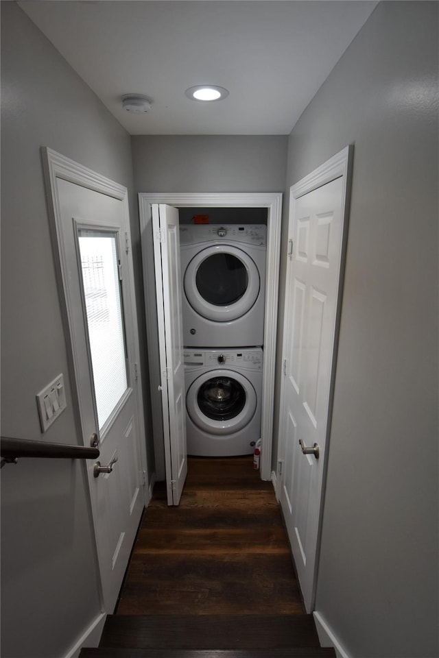 clothes washing area with recessed lighting, stacked washer and clothes dryer, dark wood-style flooring, and laundry area