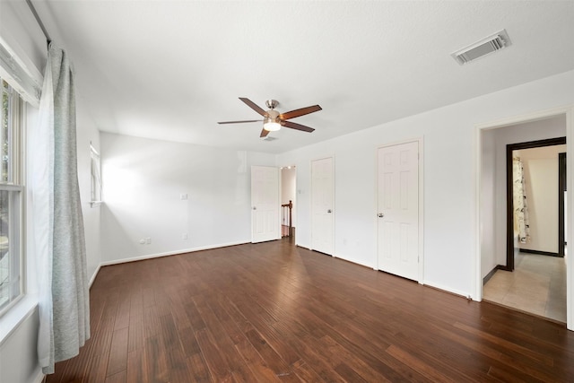 interior space with a ceiling fan, hardwood / wood-style flooring, baseboards, and visible vents