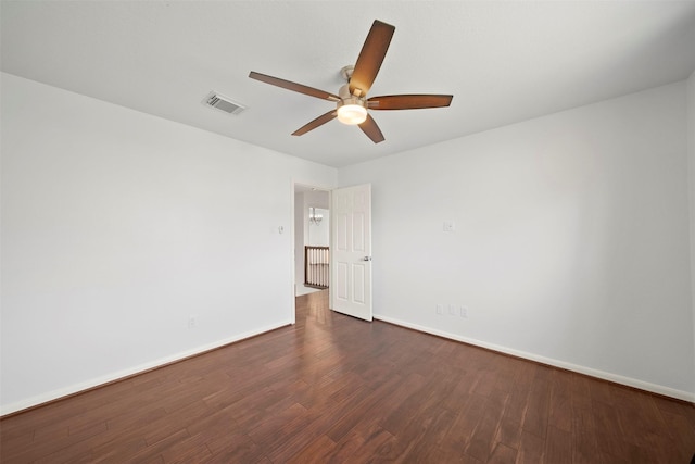 spare room with visible vents, ceiling fan, baseboards, and dark wood-style flooring