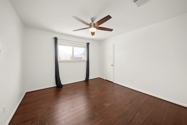 unfurnished room with dark wood finished floors, a ceiling fan, visible vents, and baseboards