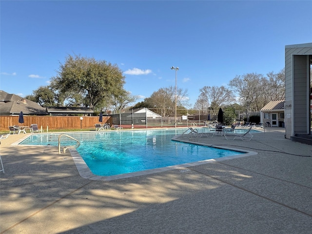 community pool featuring fence and a patio area