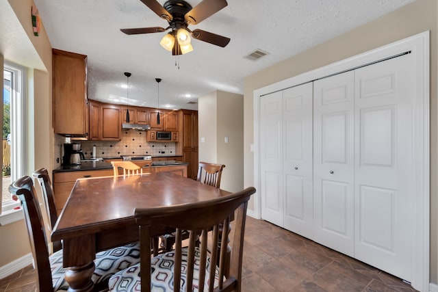 dining area featuring visible vents, ceiling fan, a textured ceiling, and baseboards