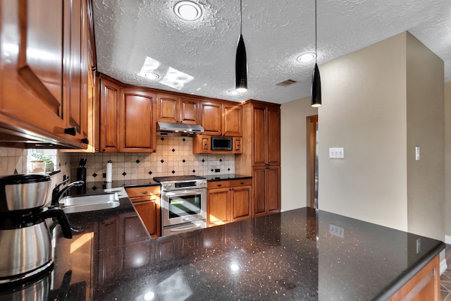 kitchen with visible vents, a sink, under cabinet range hood, appliances with stainless steel finishes, and decorative backsplash