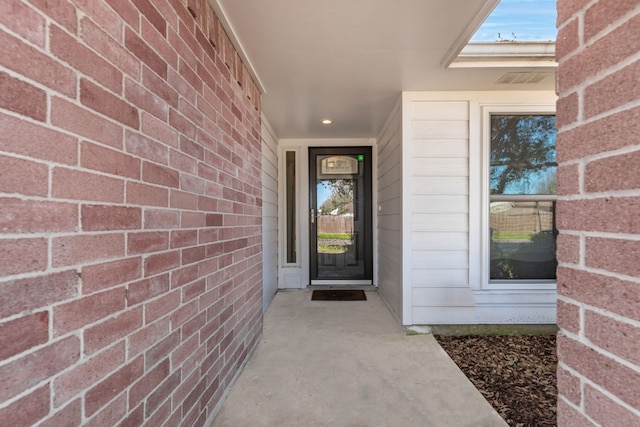 property entrance featuring brick siding