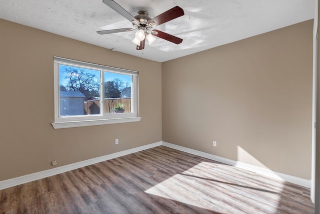 unfurnished room featuring ceiling fan, baseboards, and wood finished floors