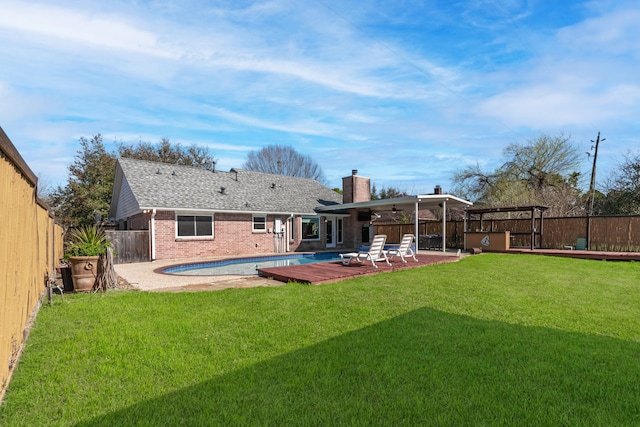 back of property featuring brick siding, ceiling fan, a lawn, a fenced backyard, and a patio