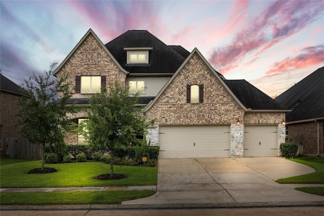 french country inspired facade with brick siding, concrete driveway, roof with shingles, and a front lawn
