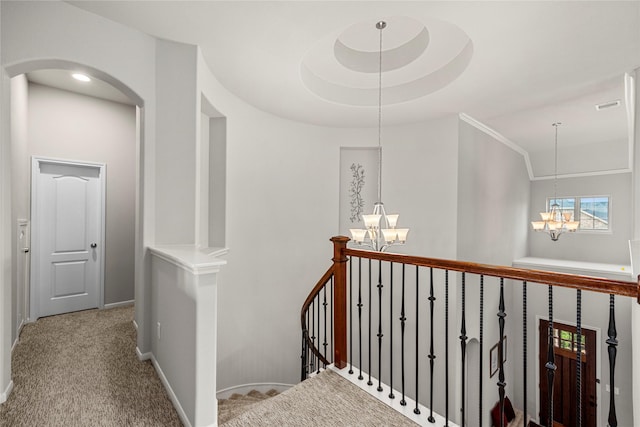 hallway with baseboards, carpet floors, visible vents, an inviting chandelier, and an upstairs landing