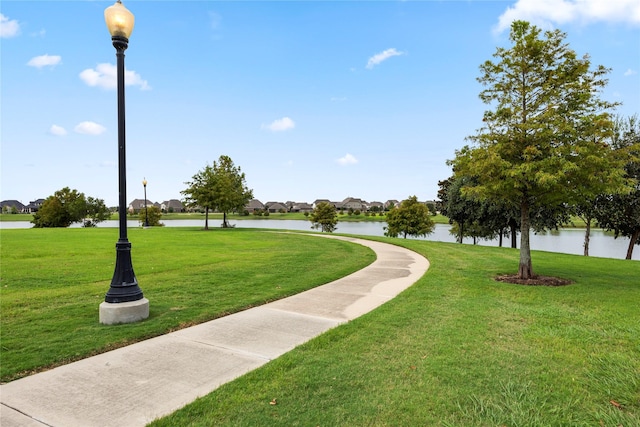 view of community with a water view and a lawn