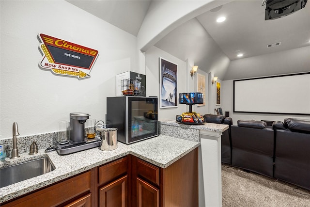 home theater with visible vents, light colored carpet, lofted ceiling, and a sink