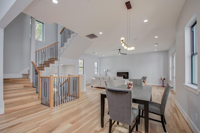 dining space featuring recessed lighting, visible vents, wood finished floors, and a glass covered fireplace