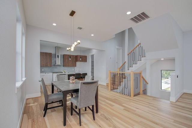 dining space featuring baseboards, visible vents, and light wood-type flooring