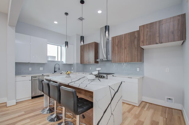 kitchen with visible vents, white cabinets, stainless steel dishwasher, wall chimney range hood, and modern cabinets