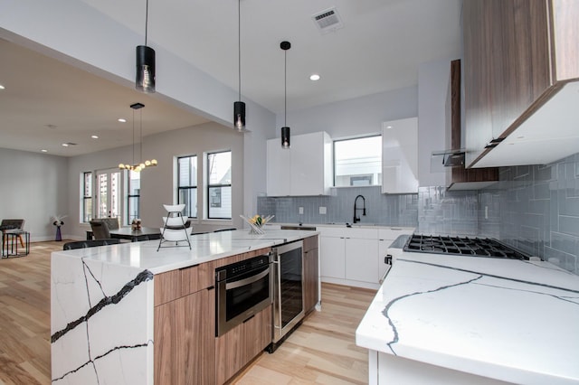 kitchen with visible vents, light stone countertops, modern cabinets, and beverage cooler