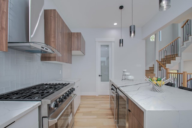 kitchen with brown cabinets, modern cabinets, wall chimney exhaust hood, and stainless steel range