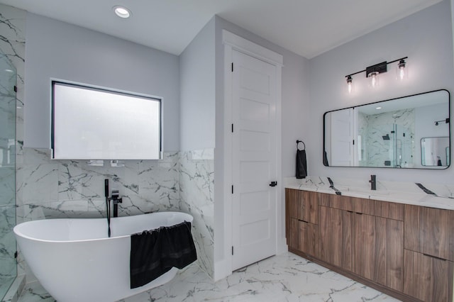 full bath featuring recessed lighting, a soaking tub, marble finish floor, and vanity