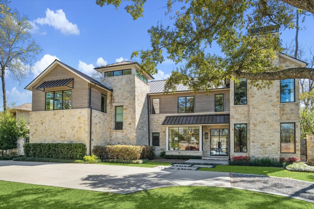 314 Hunters Trail St, Hunters Creek Village, TX 77024 - view of front of house featuring metal roof, stone siding, a front lawn, and a standing seam roof