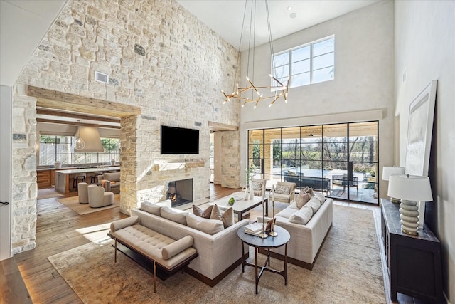 living area featuring visible vents, plenty of natural light, hardwood / wood-style floors, and a fireplace