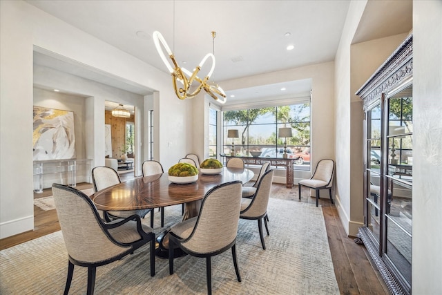 dining room with a notable chandelier, recessed lighting, baseboards, and wood finished floors