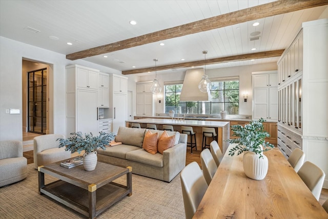 living area featuring beam ceiling and recessed lighting