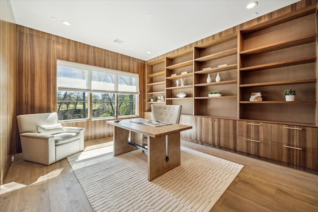 office featuring recessed lighting, visible vents, light wood-style flooring, and wooden walls