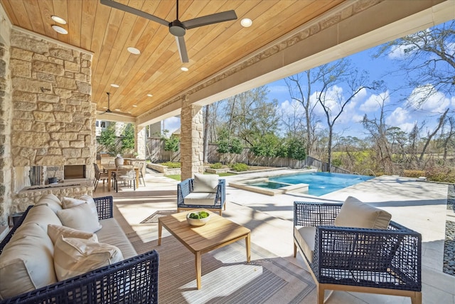 view of patio with a fenced backyard, outdoor dining space, a ceiling fan, and an outdoor living space with a fireplace