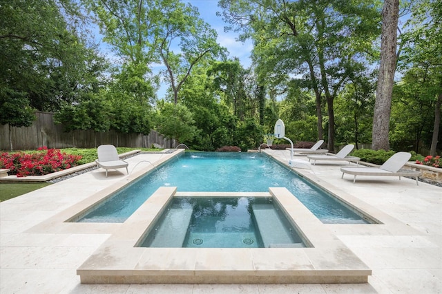 view of pool featuring a pool with connected hot tub, a patio, and fence