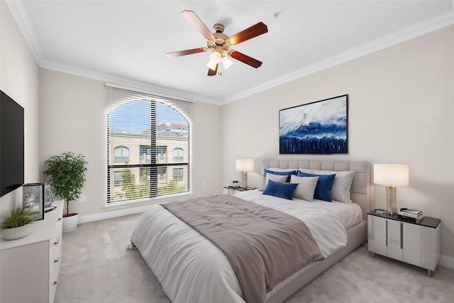 bedroom featuring light colored carpet, a ceiling fan, baseboards, and ornamental molding