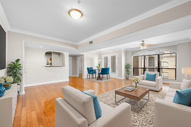 living area with light wood finished floors, visible vents, crown molding, and baseboards