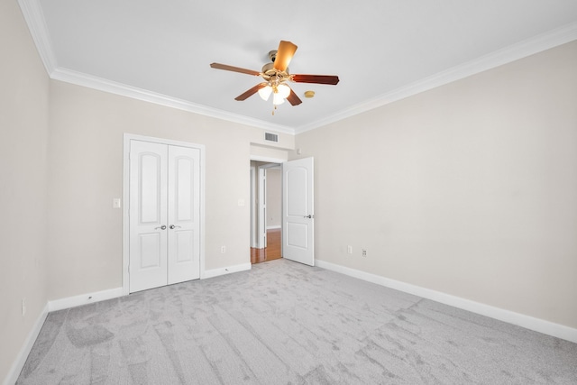 unfurnished bedroom featuring visible vents, carpet floors, baseboards, and ornamental molding