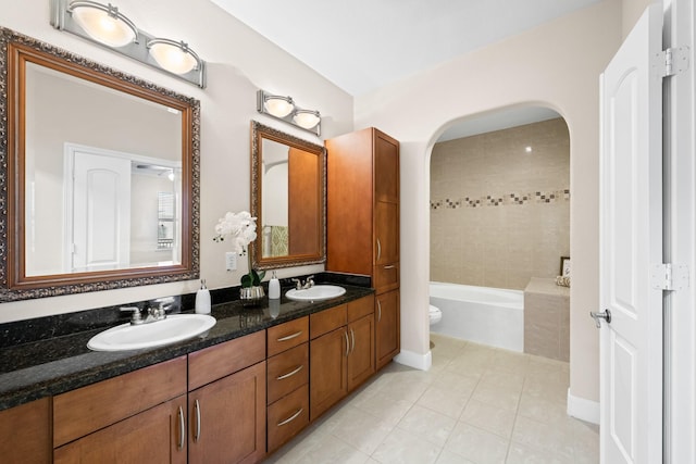 full bathroom featuring double vanity, a bath, tile patterned floors, and a sink