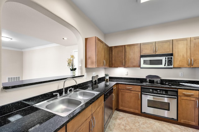 kitchen featuring visible vents, crown molding, brown cabinetry, stainless steel appliances, and a sink