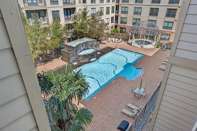 community pool with a patio area and a community hot tub