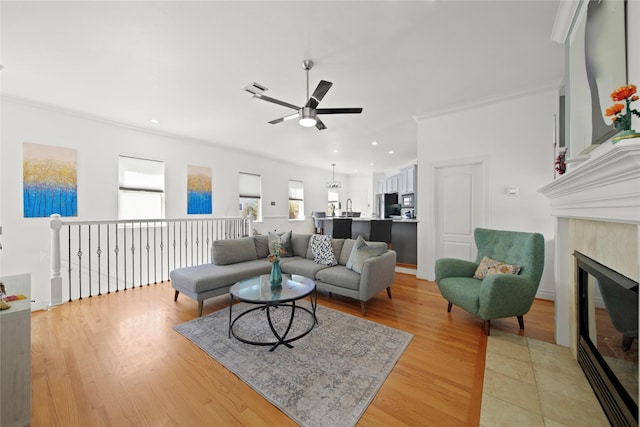 living area with visible vents, ceiling fan, recessed lighting, light wood-style flooring, and a glass covered fireplace