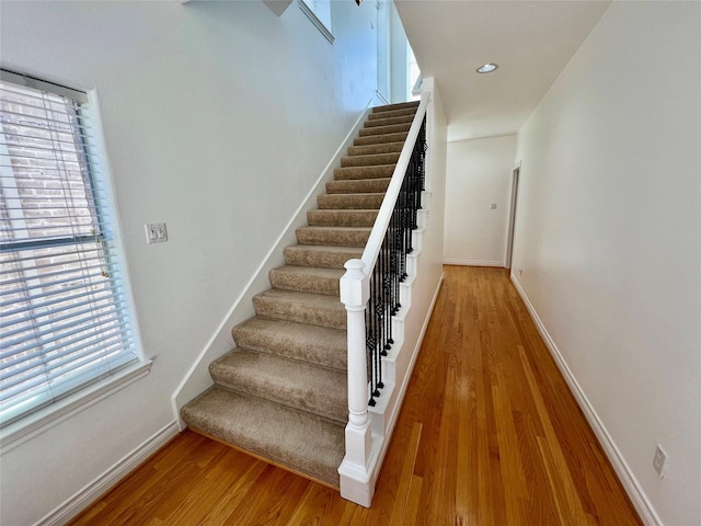 stairs featuring recessed lighting, wood finished floors, and baseboards