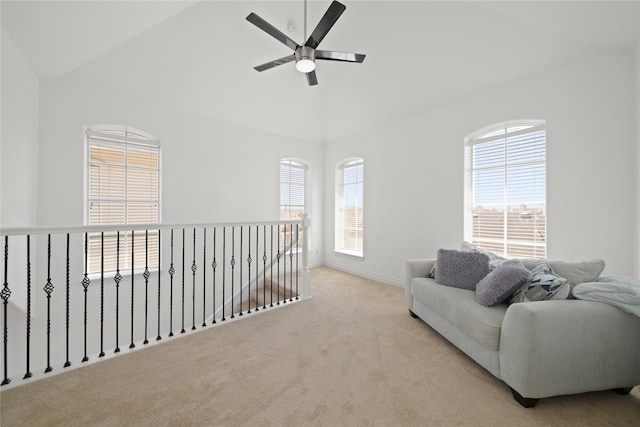 living area featuring carpet flooring, baseboards, and a ceiling fan