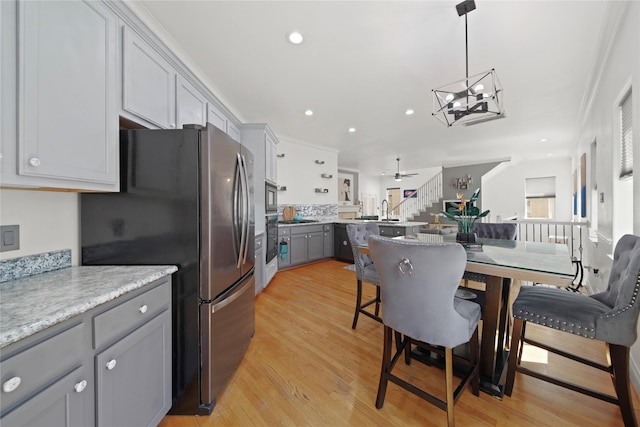 kitchen with gray cabinets, black oven, freestanding refrigerator, recessed lighting, and light wood finished floors