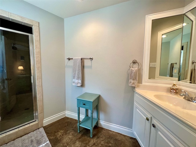 bathroom with baseboards, vanity, and a shower stall