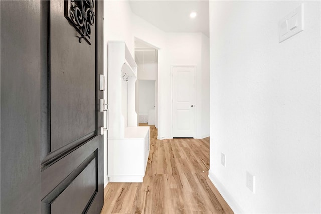 corridor with baseboards and light wood-style flooring