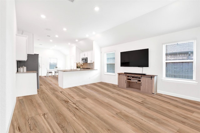 kitchen with light wood finished floors, white cabinets, and a healthy amount of sunlight