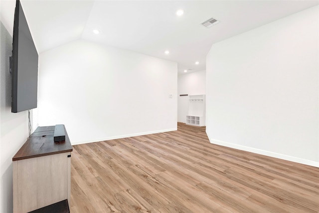 unfurnished living room featuring visible vents, light wood-style flooring, recessed lighting, baseboards, and vaulted ceiling