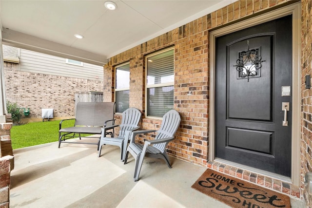 entrance to property with brick siding and covered porch