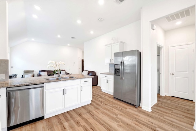 kitchen featuring visible vents, white cabinets, stainless steel appliances, and light wood-style floors