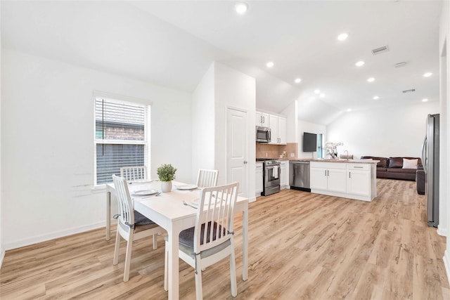 dining room featuring light wood-type flooring, visible vents, recessed lighting, baseboards, and vaulted ceiling