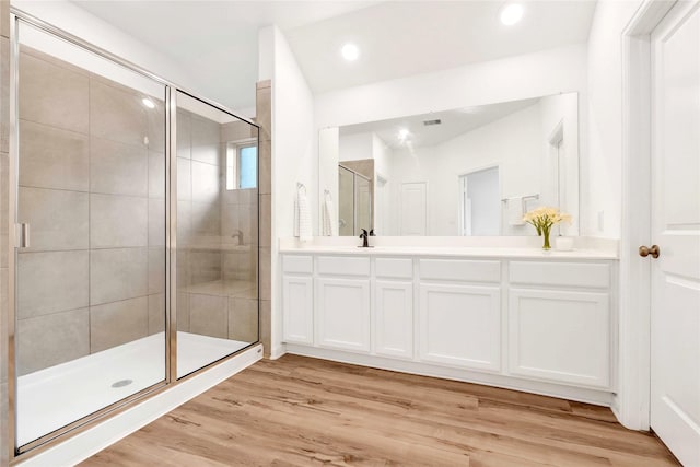 bathroom featuring vanity, a shower stall, recessed lighting, and wood finished floors