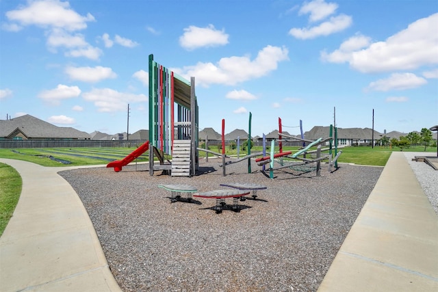 communal playground with a lawn and fence