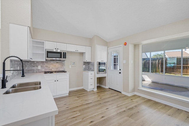 kitchen featuring a sink, light wood-style floors, appliances with stainless steel finishes, and light countertops