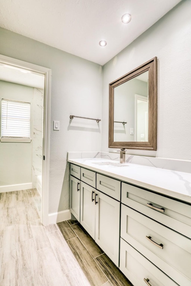 full bathroom featuring vanity, baseboards, and wood tiled floor